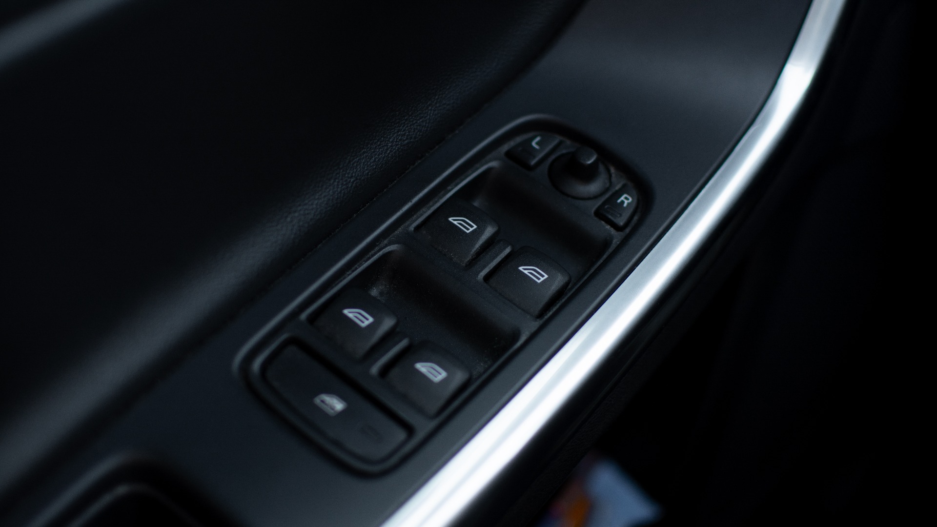 Nahaufnahme der Bedienelemente an der Fahrertür eines Volvo für die elektrischen Fensterheber, die Außenspiegelverstellung und die Heckscheibenverriegelung
